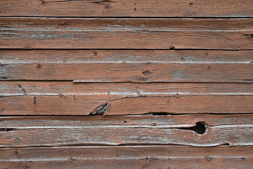 Detailed close-up of old, cracked, and weathered asphalt roof shingles, showing clear signs of aging and potential damage ...