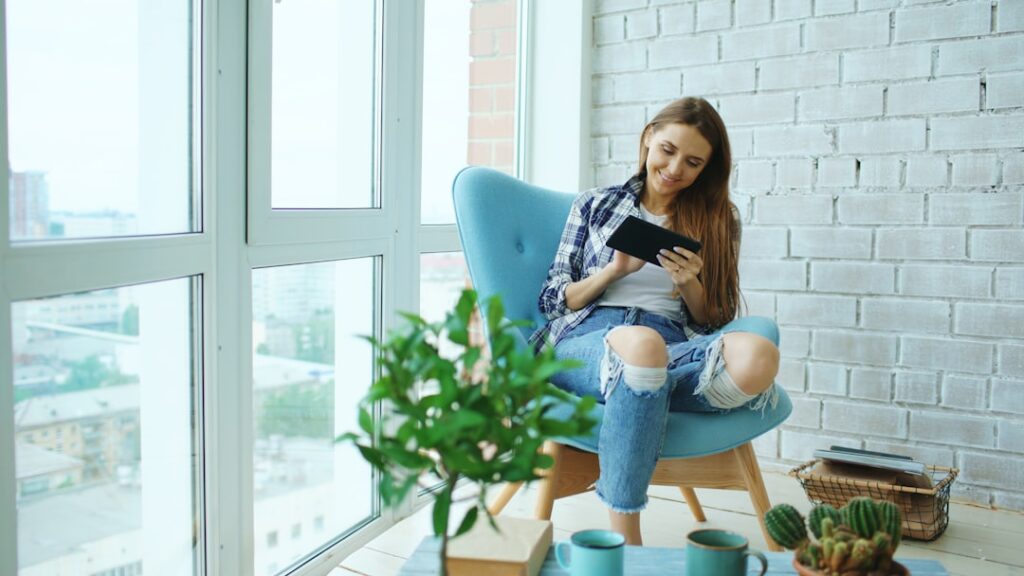 Real estate professional stands inside a bright, modern home, analyzing data on a tablet, representing expert financial ov...