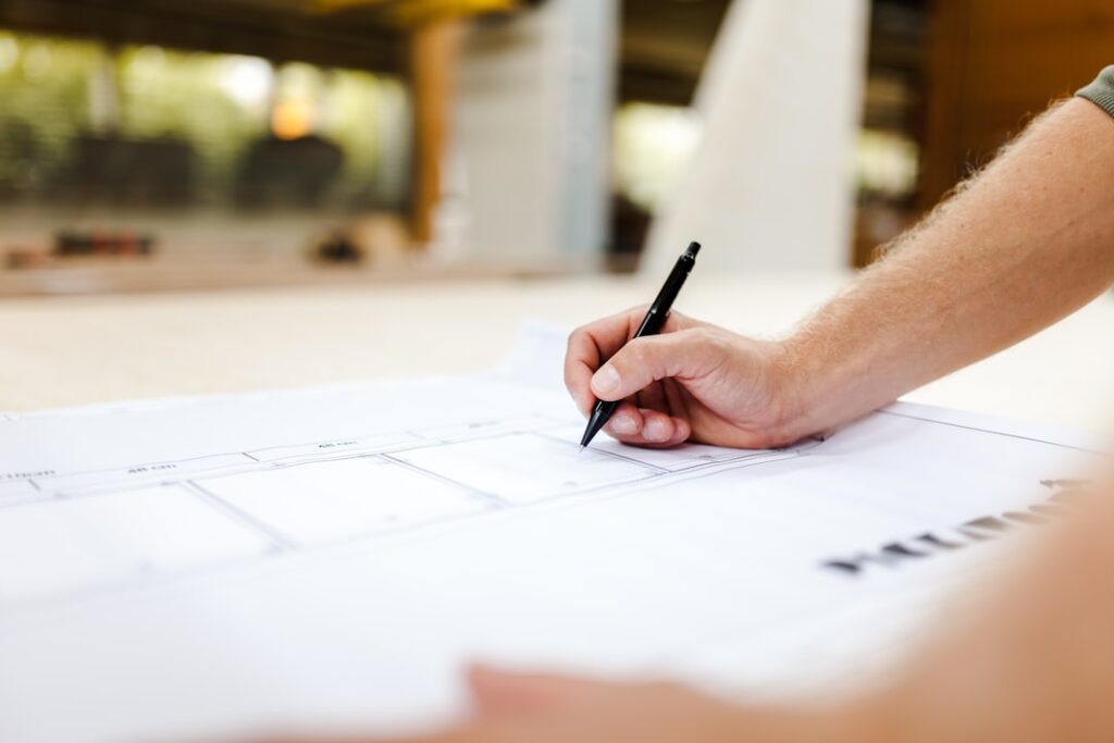 Detailed architectural blueprint is laid flat on a desk, accompanied by professional drafting tools, symbolizing a meticul...
