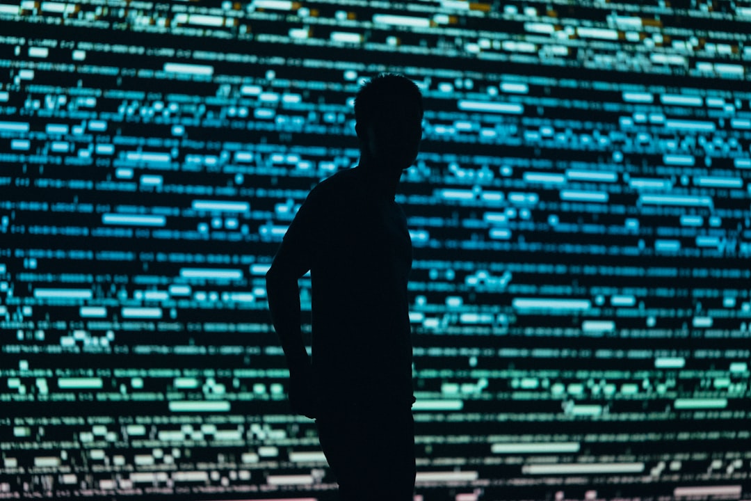 A professional in a modern office looks intently at a computer screen displaying abstract, glowing data patterns, representing the challenge of interpreting opaque AI decisions.