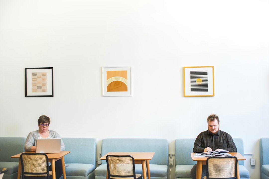 Two real estate professionals in a modern office seriously discussing paperwork, symbolizing commission negotiations.
